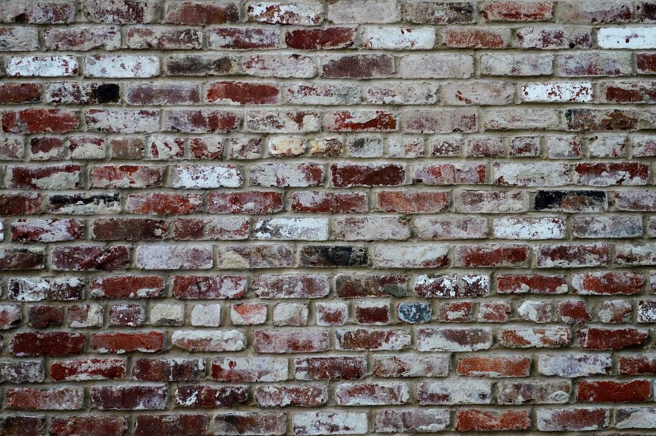 Close-up of an old wall of weathered red and gray brick